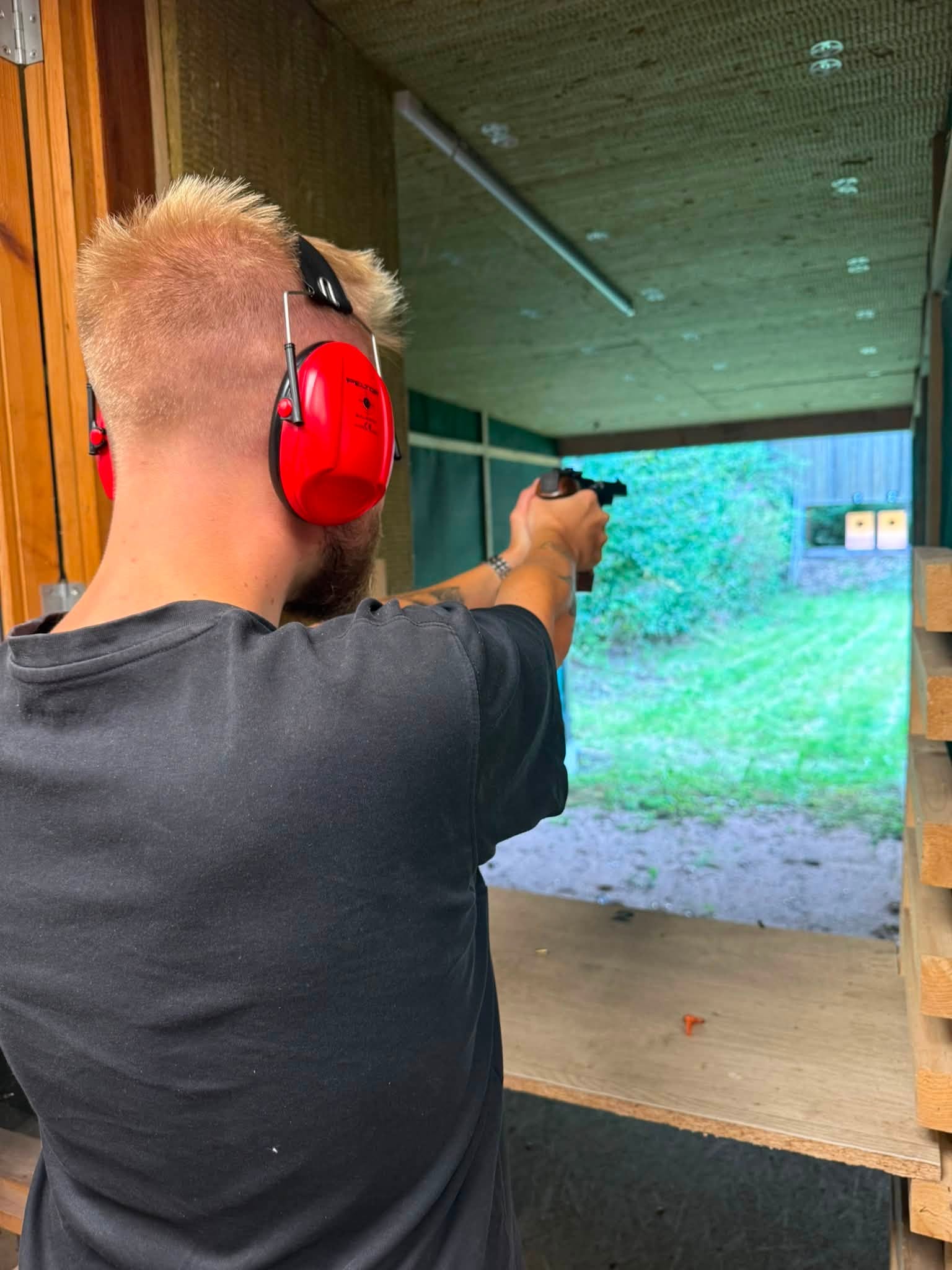 Skytte med røde høreværn på Vejle Skytteforenings pistolbane